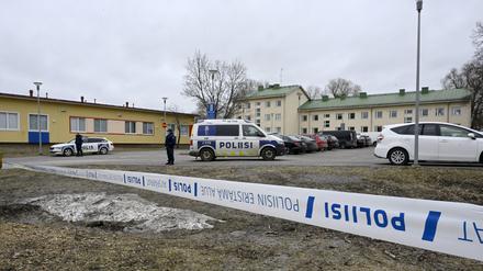 Polizeibeamte bewachen den Tatort hinter den Absperrbändern bei der Viertola-Schule in der finnischen Stadt Vantaa nördlich von Helsinki.