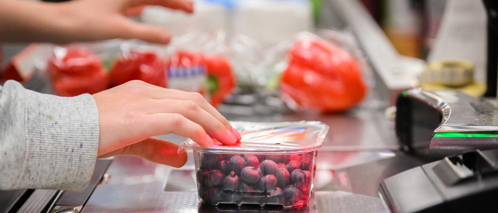 Eine Kassiererin scannt Heidelbeeren an der Kasse eines Supermarktes. (Symbolbild)