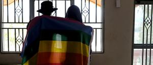 Ein Paar bedeckt sich mit einer Pride-Fahne. In Uganda hat das Verfassungsgericht ein umstrittenes Gesetz gegen Homosexuelle bestätigt.