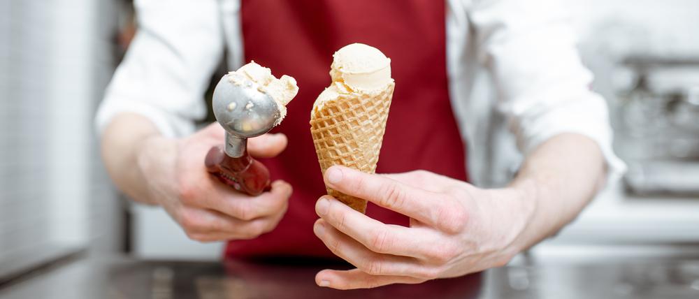Ein Eisverkäufer füllt eine Waffel mit einer Kugel Eis. (Symbolbild)