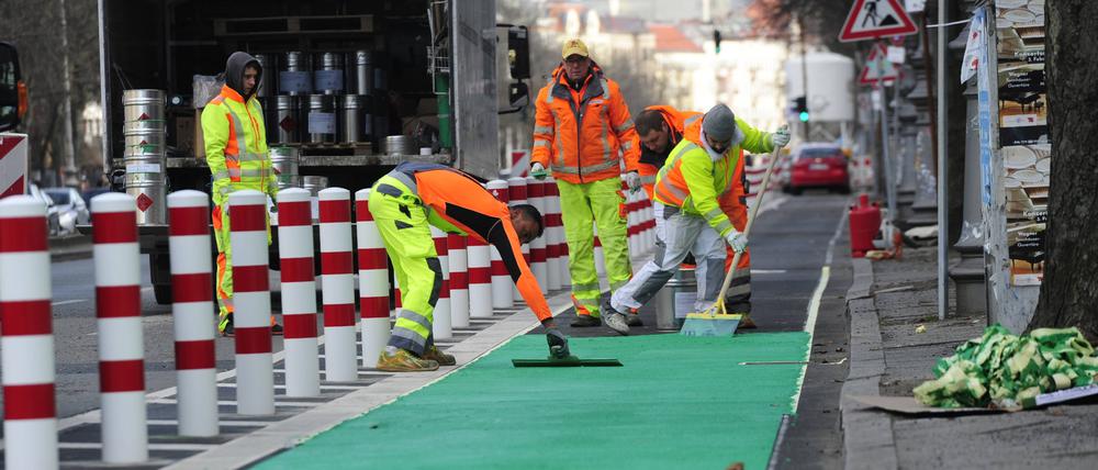 Arbeiter bringen einen Farbbelag für den geschützten Radweg auf der Straße Hasenheide auf (Symbolbild). 