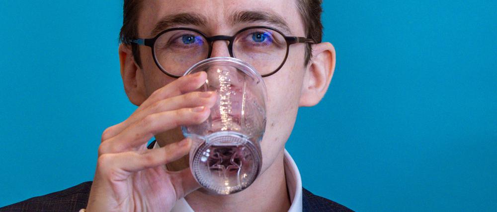 Der Bundestagsabgeordnete Philipp Amthor (CDU) trinkt nach einem Schwächeanfall bei einer Pressekonferenz ein Glas Wasser.
