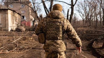 Ein Soldat läuft in der Stadt Chasiv Yar (Donezk) neben zerstörten Gebäuden, die von russischen Bomben getroffen wurden. 