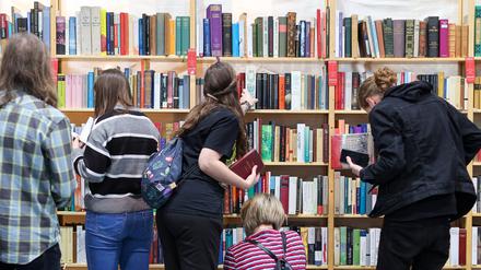 Besucher stöbern in den Regalen der Antiquariatsmesse auf der Leipziger Buchmesse.