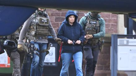 Im Innenhof eines Behördenzentrums wird die frühere RAF-Terroristin Daniela Klette zu einem Hubschrauber geführt.