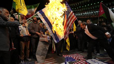 Iranische Demonstranten verbrennen US-amerikanische und israelische Fahnen, um die Tötung von Mitgliedern der iranischen Revolutionswächter (IRGC) zu verurteilen. 