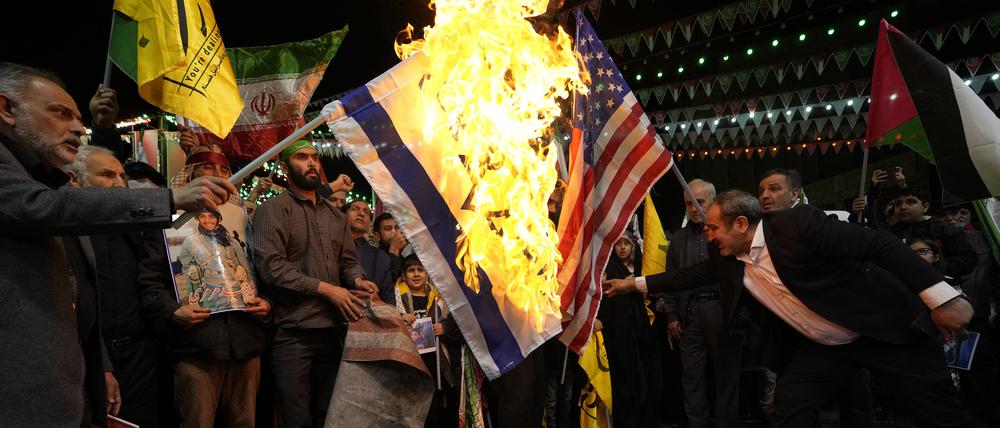 Iranische Demonstranten verbrennen US-amerikanische und israelische Fahnen, um die Tötung von Mitgliedern der iranischen Revolutionswächter (IRGC) zu verurteilen.