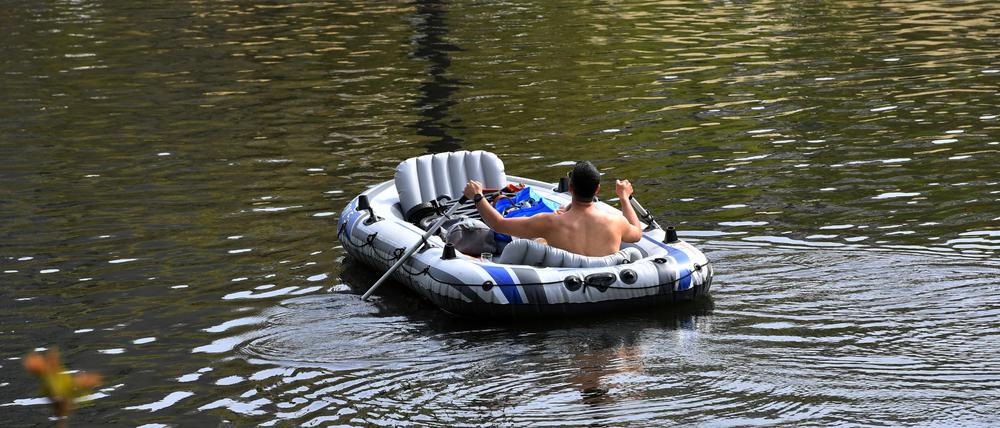 Ein Mann paddelt mit einem Schlauchboot auf dem Landwehrkanal. 