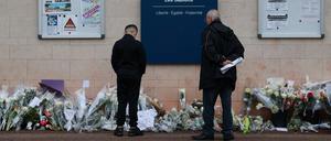 Anwohner betrachten die Blumen, die vor dem Eingang der Mittelschule Les Sablons in Viry-Chatillon niedergelegt worden sind nach dem gewaltsamen Tod eines 15-jährigen Schülers. 