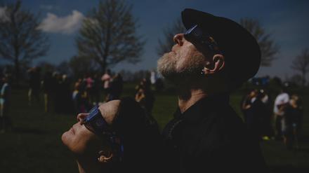 Ein frisch verheiratetes Paar blickt während einer Hochzeitszeremonie im Trenton Community Park auf eine totale Sonnenfinsternis.