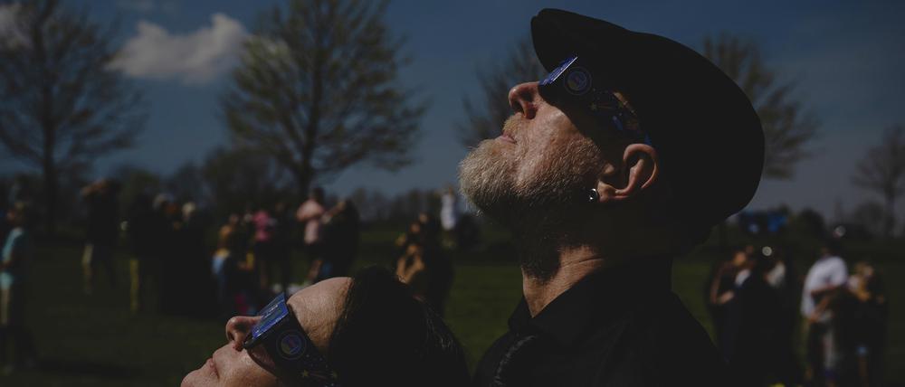 Ein frisch verheiratetes Paar blickt während einer Hochzeitszeremonie im Trenton Community Park auf eine totale Sonnenfinsternis.