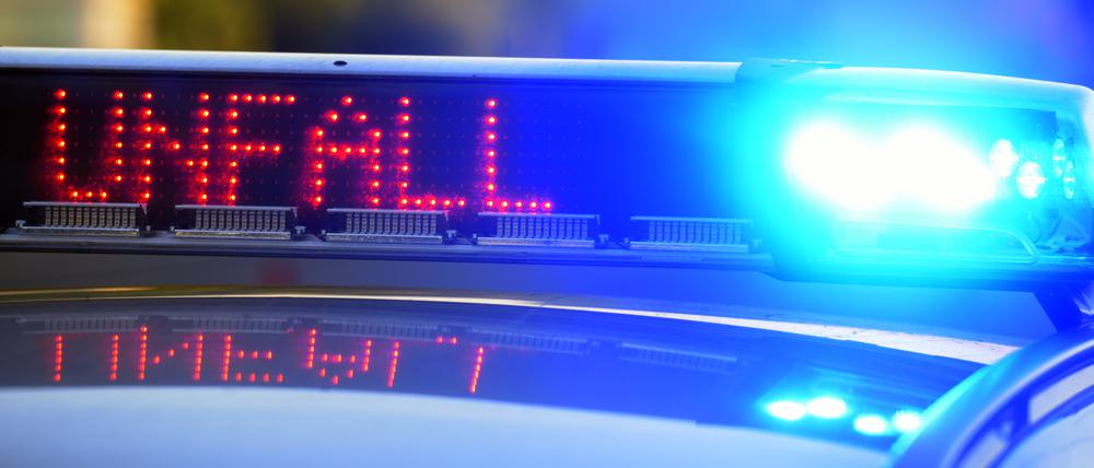 Auf einem Polizeifahrzeug warnt eine Leuchtschrift vor einer Unfallstelle. 