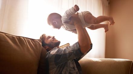Ein Vater spielt mit seinem Baby.