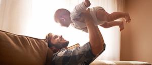 Ein Vater spielt mit seinem Baby.