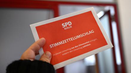 Ein Stimmzettelumschlag wird bei der Übergabe der Wahlbriefe zur SPD-Mitgliederbefragung an die Deutsche Post in die Kamera gehalten (gestellte Szene). 