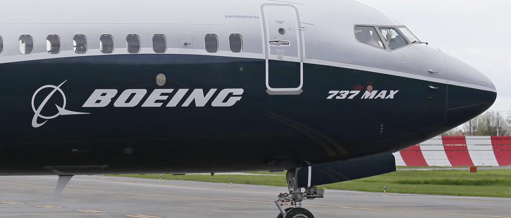 Ein Pilot winkt aus der Pilotenkabine eines Flugzeuges vom Typ Boeing 737 MAX 9 auf dem Flughafen. 