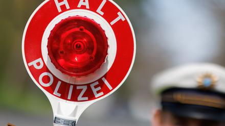 ARCHIV - 21.04.2023, Bayern, Nürnberg: Ein Polizist zieht ein Fahrzeug mit seiner Kelle aus dem Verkehr. (zu dpa: «Polizei zu «Carfreitag»: Autofans haben sich an Spielregeln gehalten») Foto: Daniel Karmann/dpa +++ dpa-Bildfunk +++