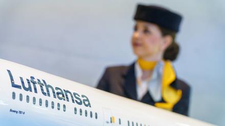 Eine Flugbegleiterin steht hinter einem Modell einer Lufthansamaschine. Bei der Lufthansa ist für das Kabinenpersonal als letzte große Beschäftigtengruppe eine Tarifeinigung erreicht worden. 