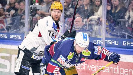 Am letzten Spieltag der Hauptrunde siegte Bremerhaven mit Phillip Bruggisser (hinten) bei den Eisbären (im Bild: Tobias Eder). Damit sicherten sich die Pinguins die Tabellenführung vor den Play-offs.