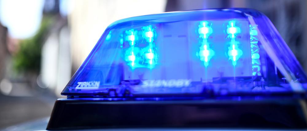 Ein Polizeiauto mit blinkendem Blaulicht steht vor einem Gebäude. (Symbolbild)