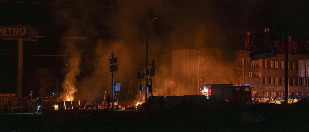 Rettungskräfte löschen das Feuer am Ort eines russischen Drohnenangriffs in Charkiw.