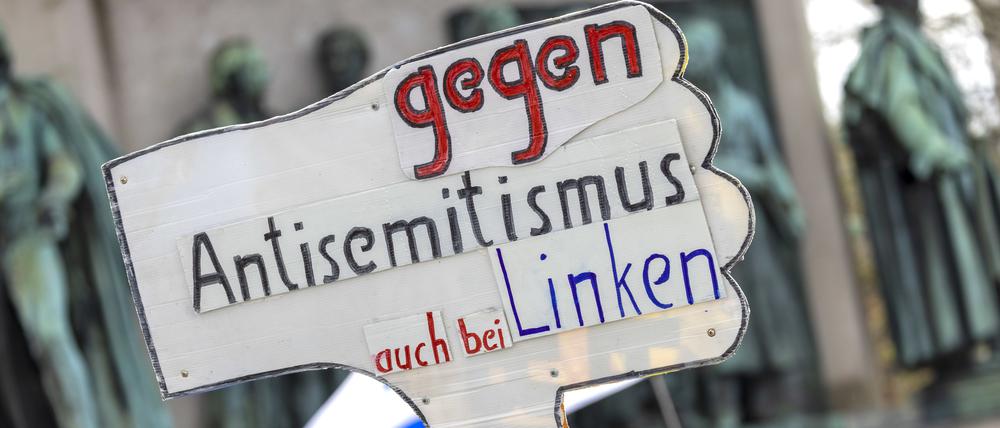 Ein Teilnehmer der Kundgebung „Allianz gegen Antisemitismus ruft zur Solidarität mit Israel auf“ hält ein Schild mit der Aufschrift „Gegen Antisemitismus auch bei den Linken“ hoch.