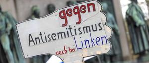Ein Teilnehmer der Kundgebung „Allianz gegen Antisemitismus ruft zur Solidarität mit Israel auf“ hält ein Schild mit der Aufschrift „Gegen Antisemitismus auch bei den Linken“ hoch.