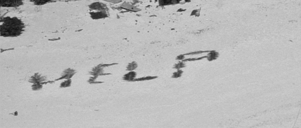 An einem Strand auf der Insel Pikelot ist die Botschaft «Help» mit Palmwedeln geschrieben. 
