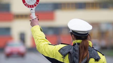 Sachsen-Anhalt, Magdeburg: Eine Polizistin winkt mit einer Kelle ein Auto von der Straße (Archivbild vom 03.04.2019).