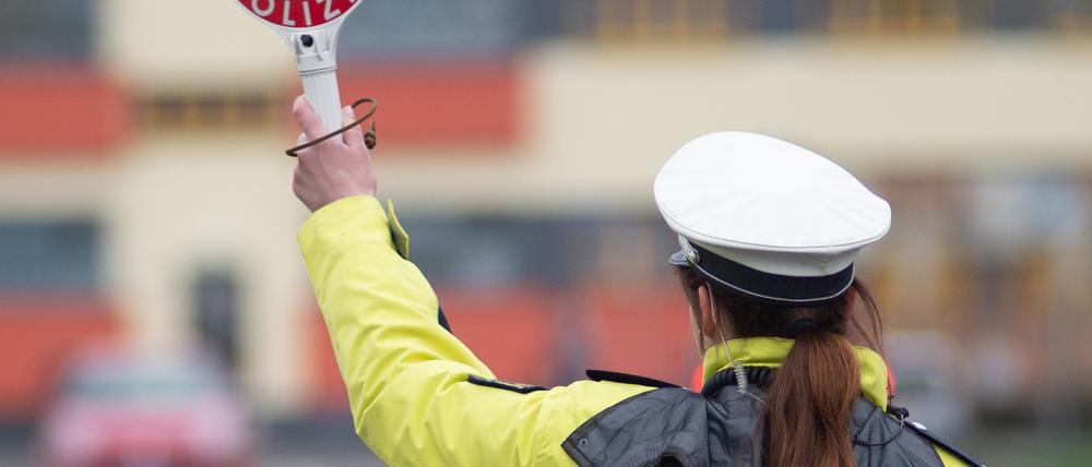 Sachsen-Anhalt, Magdeburg: Eine Polizistin winkt mit einer Kelle ein Auto von der Straße (Archivbild vom 03.04.2019).
