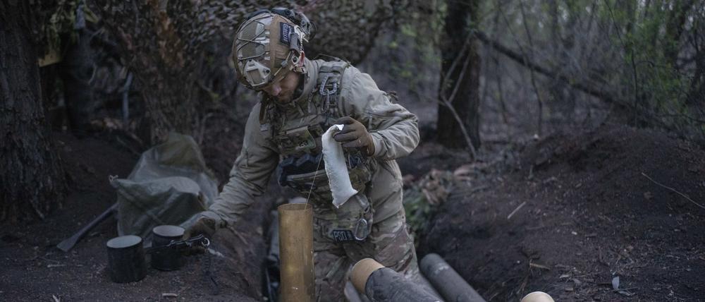 dpatopbilder - 11.04.2024, Ukraine, Donezk: Ein ukrainischer Soldat der Asow-Brigade  bereitet Granaten für eine Gebirgshaubitze Modell 56 an der Frontlinie in Richtung Kreminna, Region Donezk vor. Foto: Alex Babenko/AP/dpa +++ dpa-Bildfunk +++