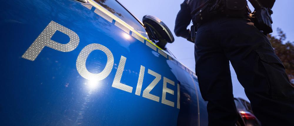 Eine Polizistin steht neben einem Polizeifahrzeug. (Symbolbild)