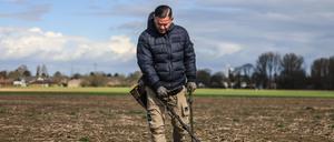 Moderne Schatzsuche. Profi-Sondengänger Carsten Konze läuft mit seinem Detektor über ein Feld. 