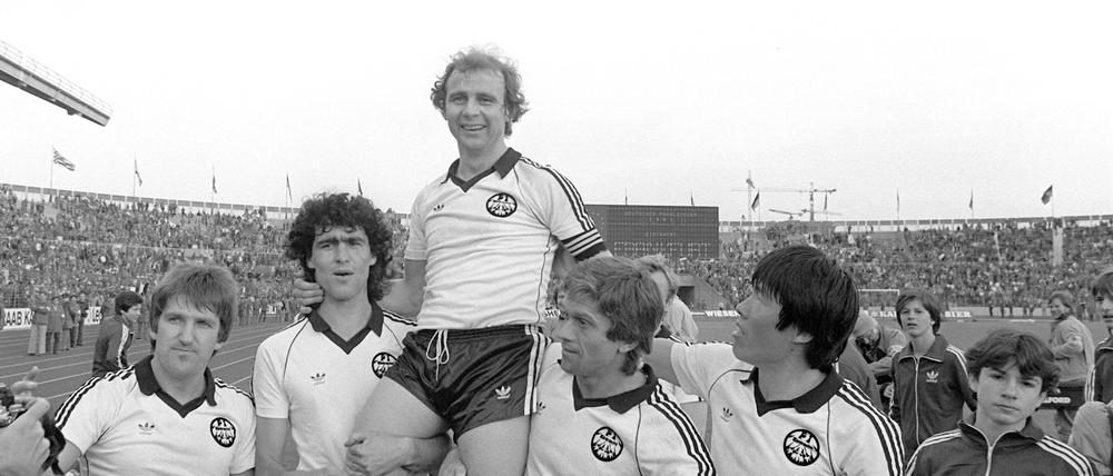 Pokalsieger. Eintracht-Stürmer und Kapitän Bernd Hölzenbein (oben) wird bei Spielende von seinen Teamgefährten Bernd Nickel (l-r), Bruno Pezzey sowie Werner Lorant und Bum-Kun Cha auf Schultern getragen.