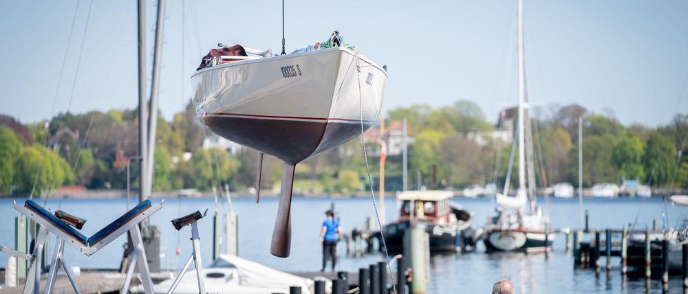 23.04.2020, Berlin: Ein Segelboot wird im Hafen des Vereins Seglerhaus am Wannsee mit einem Kran ins Wasser gelassen. Nach den Lockerungen der Beschränkungen im Rahmen der Coronakrise dürfen nun unter strengen Auflagen die Häfen rund um den Wannsee von ihren Mitgliedern besucht werden und die Boote mit Verspätung geslippt werden. Foto: Kay Nietfeld/dpa +++ dpa-Bildfunk +++