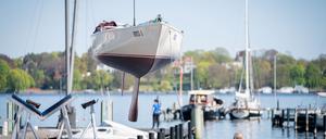 23.04.2020, Berlin: Ein Segelboot wird im Hafen des Vereins Seglerhaus am Wannsee mit einem Kran ins Wasser gelassen. Nach den Lockerungen der Beschränkungen im Rahmen der Coronakrise dürfen nun unter strengen Auflagen die Häfen rund um den Wannsee von ihren Mitgliedern besucht werden und die Boote mit Verspätung geslippt werden. Foto: Kay Nietfeld/dpa +++ dpa-Bildfunk +++