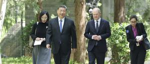 Der chinesische Präsident Xi Jinping und Bundeskanzler Olaf Scholz (SPD, 2.v.r.) gehen am Rande ihres Treffens zusammen ein paar Schritte.