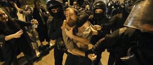 Polizeibeamte halten einen Demonstranten während einer Demonstration vor dem Parlamentsgebäude.
