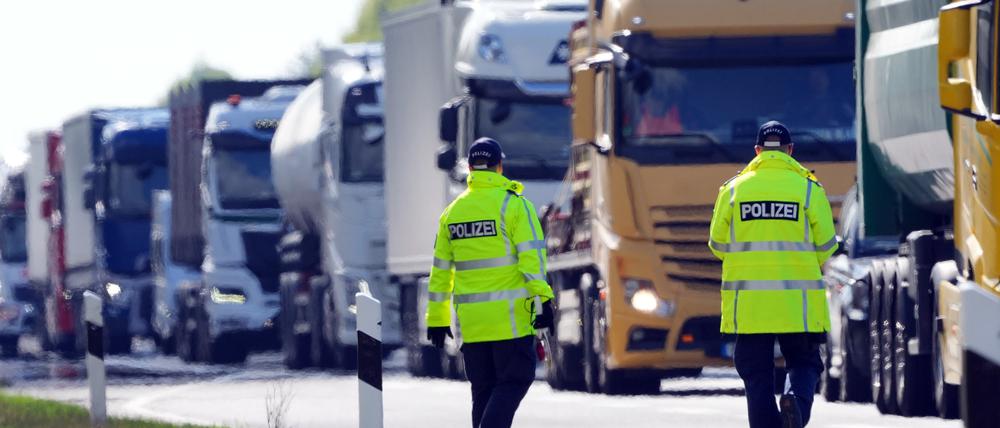 17.04.2024, Brandenburg, Walsleben: Polizeibeamte stehen kurz vor der Abfahrt zum Parkplatz Rosskower Heide an der Autobahn A 24 und winken Lastwagen aus dem fliessenden Verkehr, die an einer Kontrollstelle den Abstand zum vorausfahrenden Fahrzeug mutmaßlich unterschritten hatten. Die Abstandsmessung der Fahrzeuge erfolgte mit Hilfe einer Drohne. Foto: Soeren Stache/dpa +++ dpa-Bildfunk +++