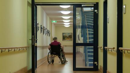 Eine Bewohnerin des Pflegeheims rollt im Rollstuhl durch den Flur Flur im Pflegeheim *** A resident of the nursing home rolls through the hall in a wheelchair 