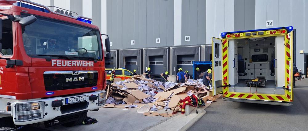 Die Potsdamer Feuerwehr bei einem Rettungseinsatz im Gewerbegebiet Friedrichspark. Einsatzkräfte entleeren gerade eine Papierpresse, in die zuvor ein Mensch geraten ist. 