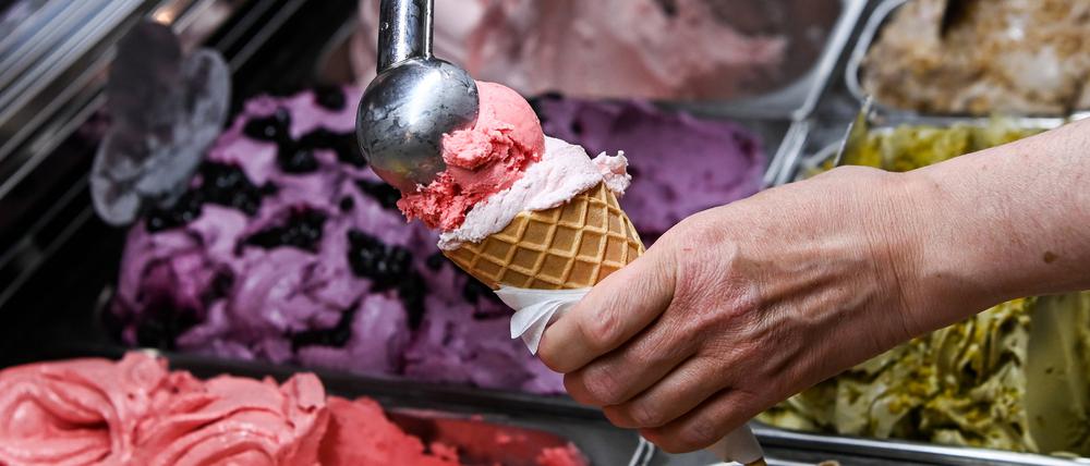 ARCHIV - 24.05.2022, Berlin: Eine Kugel Erdbeereis wird in einer Eisdiele auf eine weitere Kugel in einem Waffelhörnchen gesetzt. (zu dpa: ««Gelato Week Berlin» - Spezielle Eissorten zum Probieren») Foto: Jens Kalaene/dpa +++ dpa-Bildfunk +++