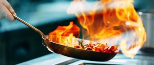 Modern kitchen. Cooks prepare meals on the stove in the kitchen of the restaurant or hotel. The fire in the kitchen
