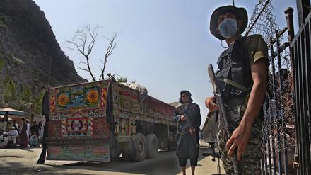ARCHIV - 21.08.2021, Pakistan, Torkham: Ein pakistanischer Soldat (r) und Kämpfer der Taliban stehen Wache an einem Grenzübergang zwischen Pakistan und Afghanistan in der Provinz Khyber Pakhtunkhwa auf den jeweiligen Seiten der Länder. (zu dpa: «Sieben Tote bei Kämpfen an pakistanisch-afghanischer Grenze») Foto: -/AP/dpa +++ dpa-Bildfunk +++
