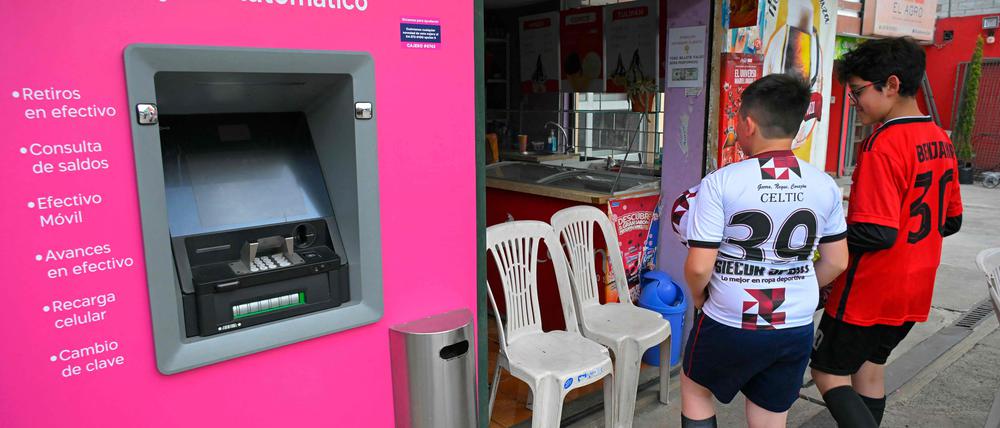 Kinder warten vor einem nicht beleuchteten Geschäft in Quito.