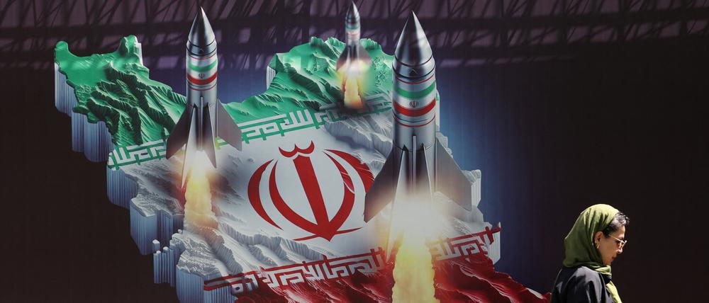An Iranian woman walks past an anti-Israel banner with a picture of Iranian missiles on a street in Tehran, Iran April 19, 2024. Majid Asgaripour/WANA (West Asia News Agency) via REUTERS ATTENTION EDITORS - THIS IMAGE HAS BEEN SUPPLIED BY A THIRD PARTY.   ATTENTION EDITORS - THIS PICTURE WAS PROVIDED BY A THIRD PARTY. 
