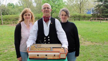 Projektleiterin Stefanie Hutsch (l.), Zimmerermeister Robert Jentsch und Vereinsvorsitzende Inga Schütt vom Verein Kids & Co. mit dem Modell der Mitmachbaustelle in Marzahn-Hellersdorf.