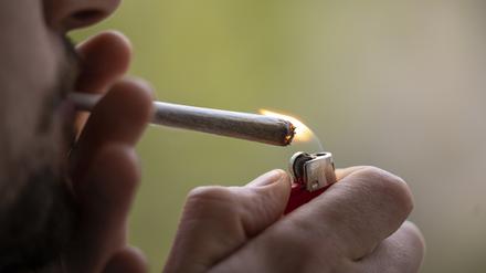 Ein Mann zündet sich einen Joint an. 