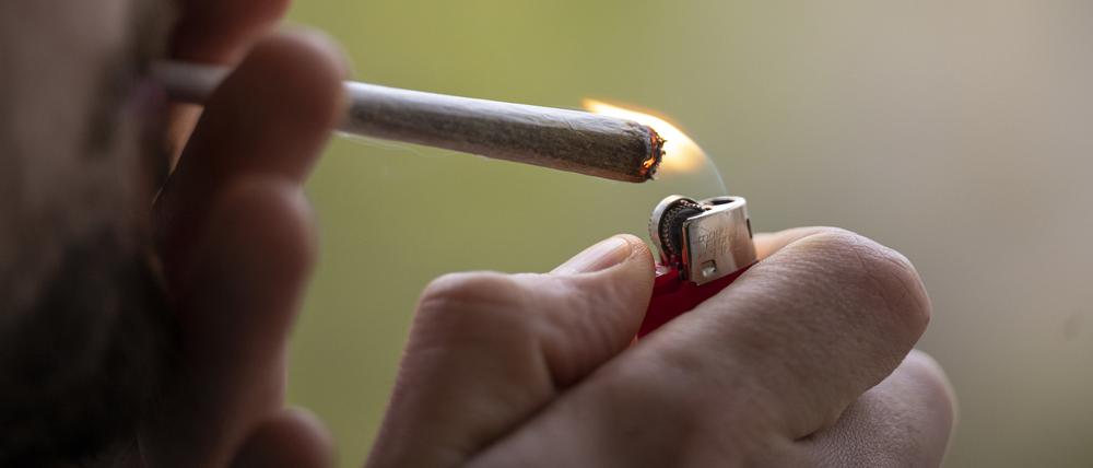 Ein Mann zündet sich einen Joint an.