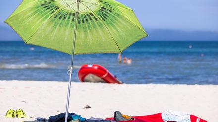 ARCHIV - 15.07.2021, Mecklenburg-Vorpommern, Prerow: Ein großer Sonnenschirm steht am Strand an der Ostseeküste.  